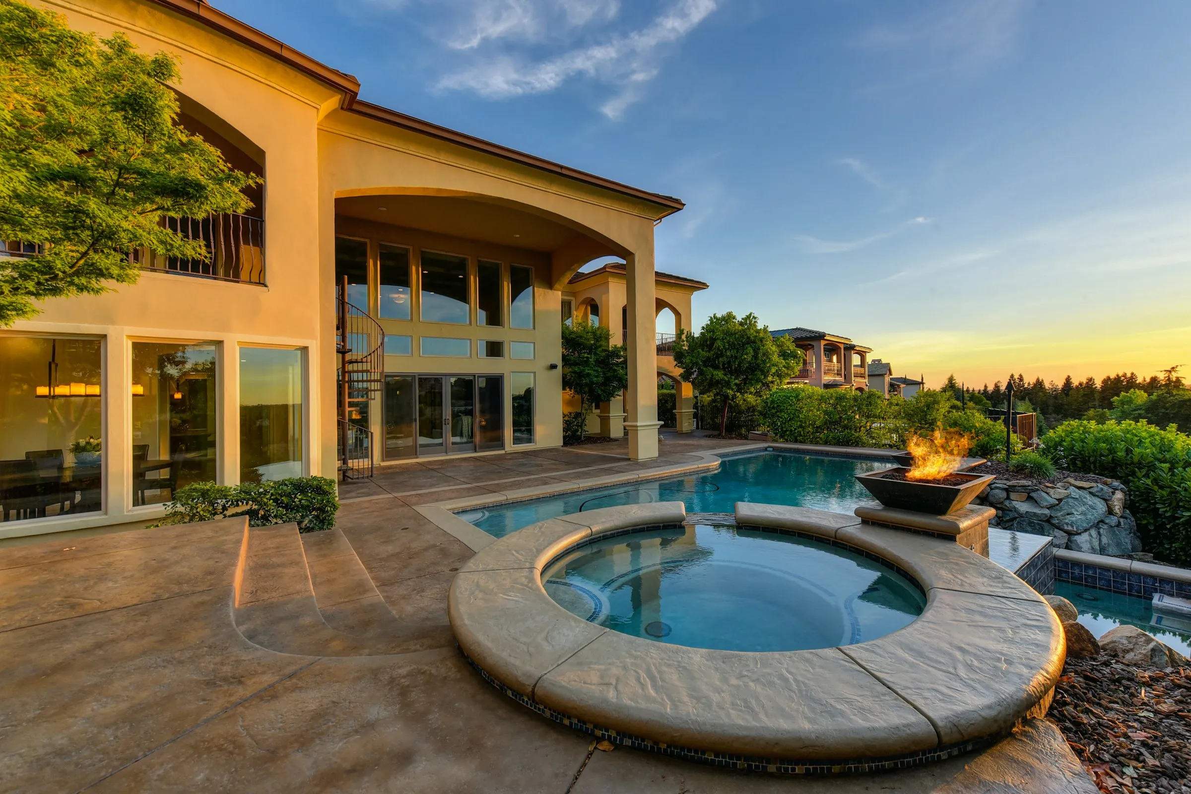 Spanish-style home with a pool at golden hour